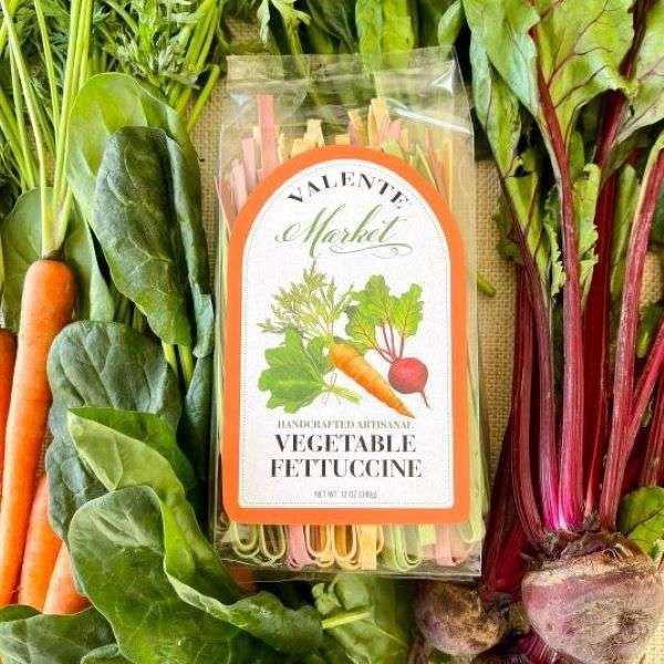Vegetable Fettuccine Sold by The Olive Tap: A package of vegetable fettucine surrounded by fresh beets, carrots, and leafy greens.