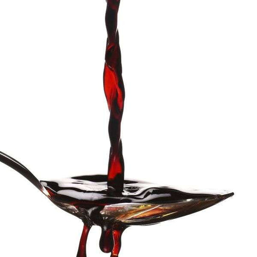 Red Aceto 4 Balsamic Vinegar of Modena dripping on a spoon with a white background.
