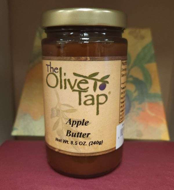 A jar of Apple Butter from The Olive Tap with a colorful background.
