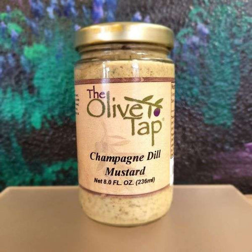 Champagne Dill Mustard from The Olive Tap in a glass jar with a turquoise, black, and purple background.