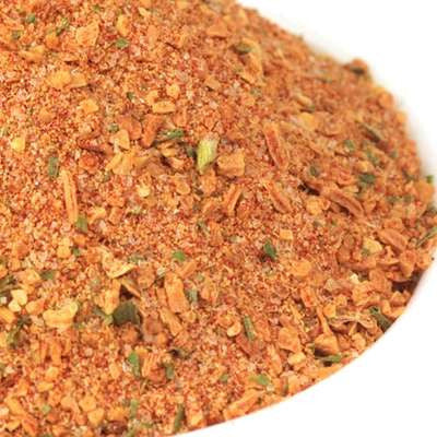 Chop House Burger Seasoning from The Olive Tap: A white bowl with orange and green spices of different sizes.
