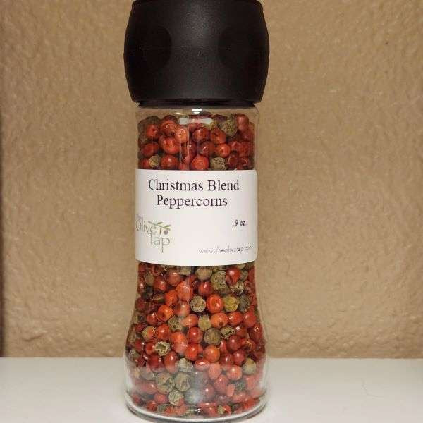 Christmas Blend Peppercorns:  Red and brown peppercorns in a grinder jar from The Olive Tap against a neutral background.