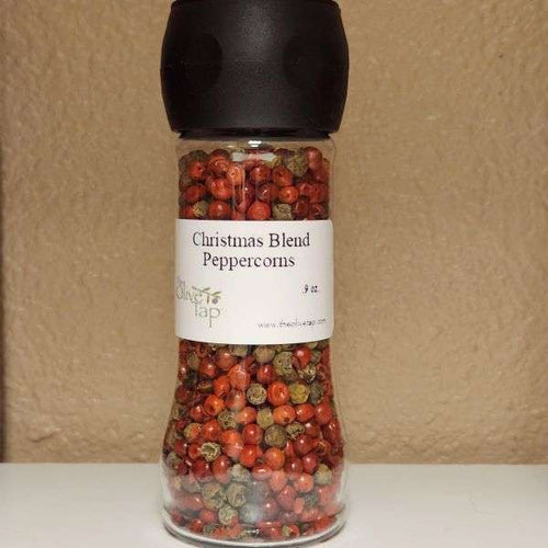 Christmas Blend Peppercorns:  Red and brown peppercorns in a grinder jar from The Olive Tap against a neutral background.