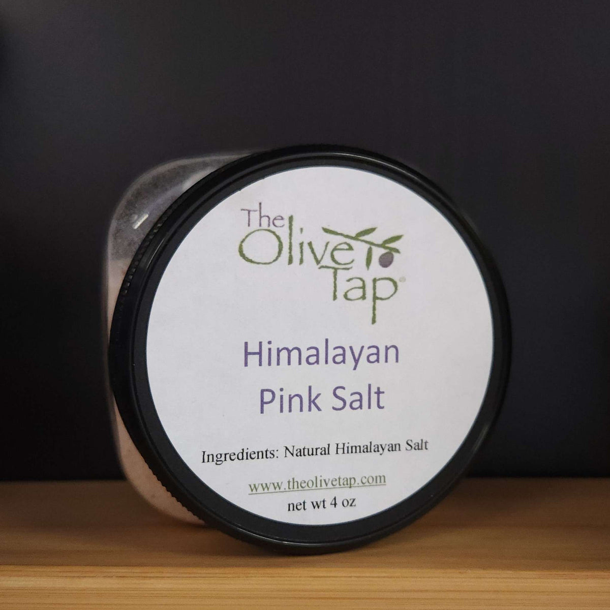Himalayan Pink Salt 4 oz Jar from The Olive Tap with a white label that includes ingredients, The Olive Tap logo with an olive branch, and the product name.