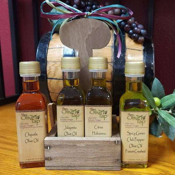 The Hot Pepper Olive Oil Sampler Box: the image displays four bottles of The Olive Tap olive oil in front of a wooden crate.