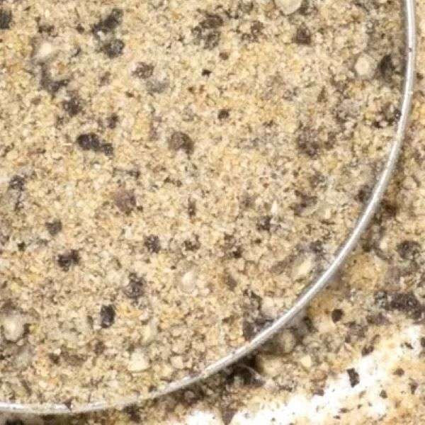 Garlic Pepper Seasoning from The Olive Tap: A metal bowl of tan ground spices with brown pieces and flakes.