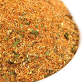 Salt-Free Spicy Thai Seasoning from The Olive Tap: A white bowl of tan, green, orange, and brown spices of different sizes mixed together.