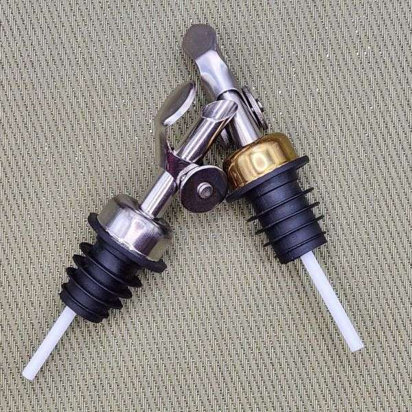 Silver and Gold Weighted Pour Spouts from The Olive Tap on a sage background.